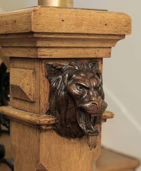 Détail de la sculpture sur le départ de l'escalier. Motif animal : hure de sanglier.