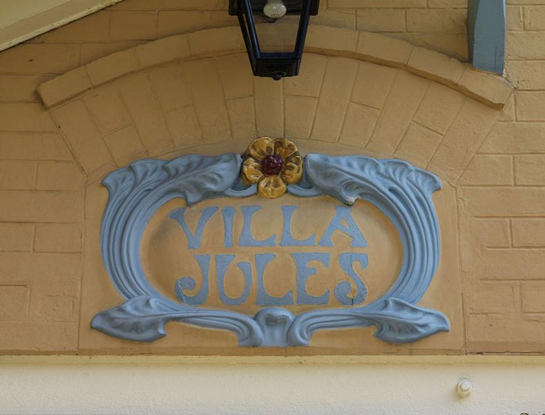 Détail du nom de la villa 'Villa Jules' disposé dans un cartouche au dessus de la porte d'entrée