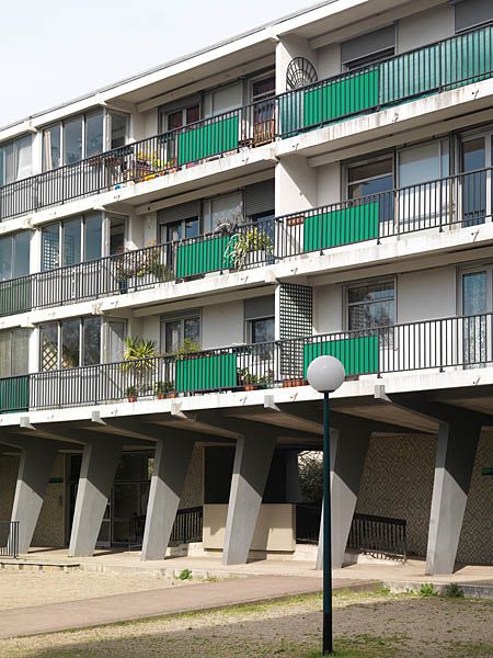 Façade non rénovée avec balcons et mosaïque d'origine.