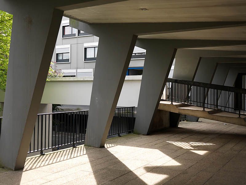 Les pilotis et une passerelle depuis une coursive du rez-de-chaussée.