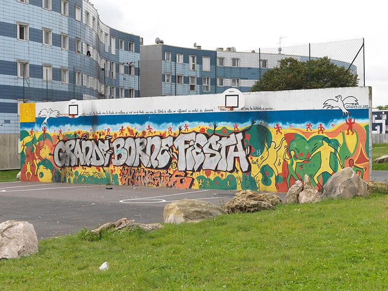 Vue de l'aire de jeux à coté du quartier des Balances, avec mur couvert de graffiti.