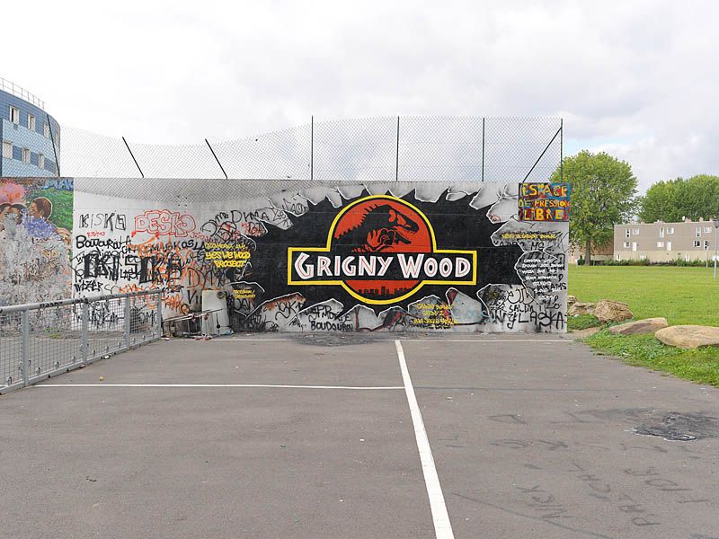 Vue de l'aire de jeux à coté du quartier des Balances, avec mur couvert de graffiti.