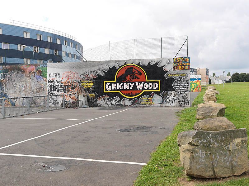 Vue de l'aire de jeux à coté du quartier des Balances, avec mur couvert de graffiti.