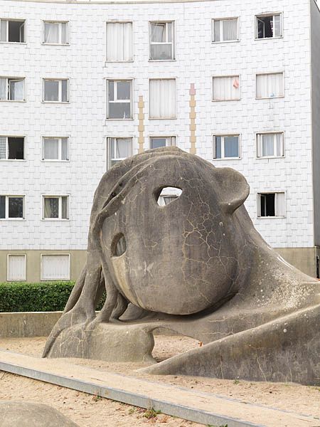 Place de l'Oeuf, aire de jeux avec la sculpture de Gulliver. Tête émergeant du sable.