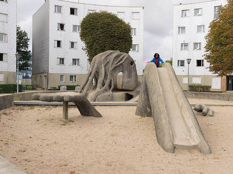 Place de l'Oeuf, aire de jeux avec la sculpture de Gulliver. Vue d'ensemble avec enfant.