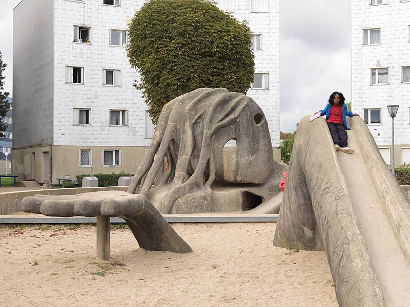 Place de l'Oeuf, aire de jeux avec la sculpture de Gulliver. Vue d'ensemble avec enfant.