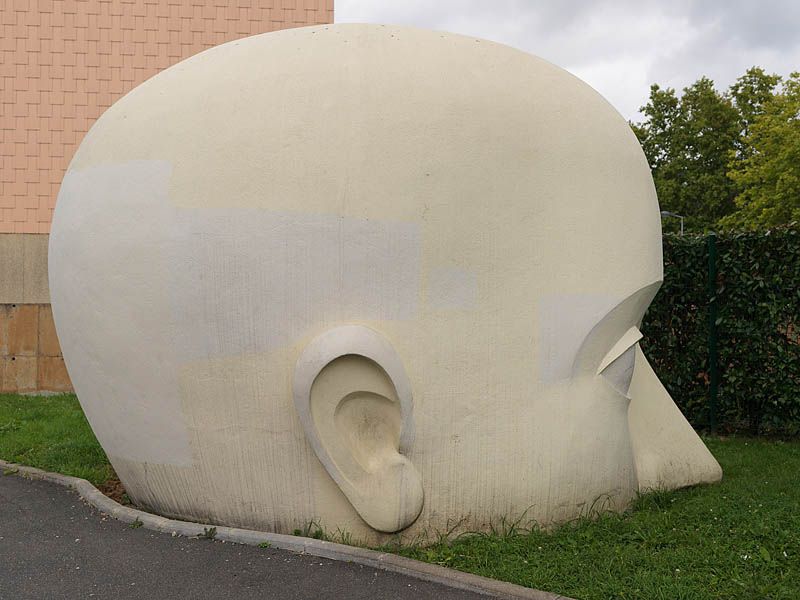 Sculpture monumentale d'une tête en béton rue du minotaure.