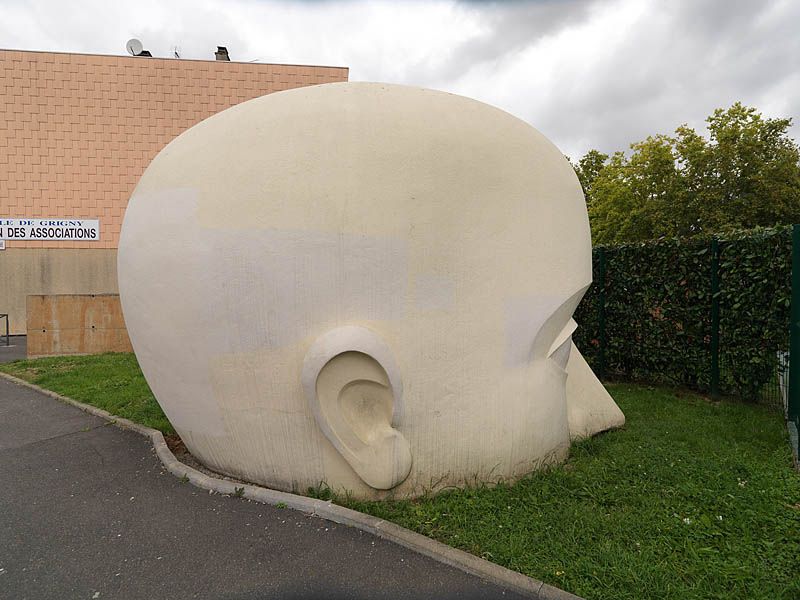 Sculpture monumentale d'une tête en béton rue du minotaure.