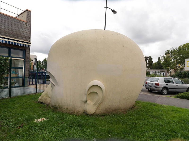 Sculpture monumentale d'une tête en béton rue du minotaure.