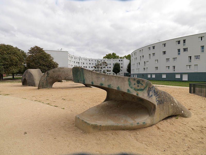 Quartier des Radras, vue de la place de l'étang avec une sculpture de serpent en béton.