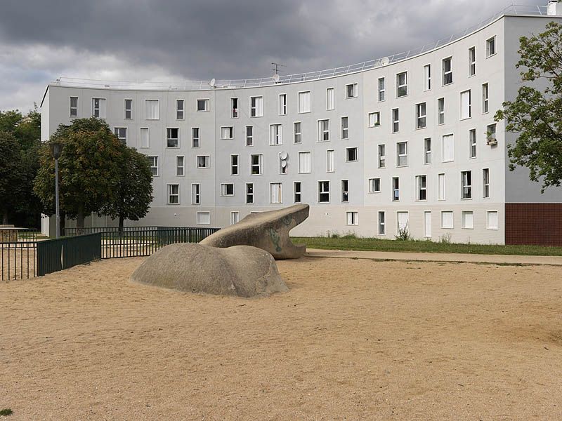 Quartier des Radras, vue de la place de l'étang avec une sculpture de serpent en béton.