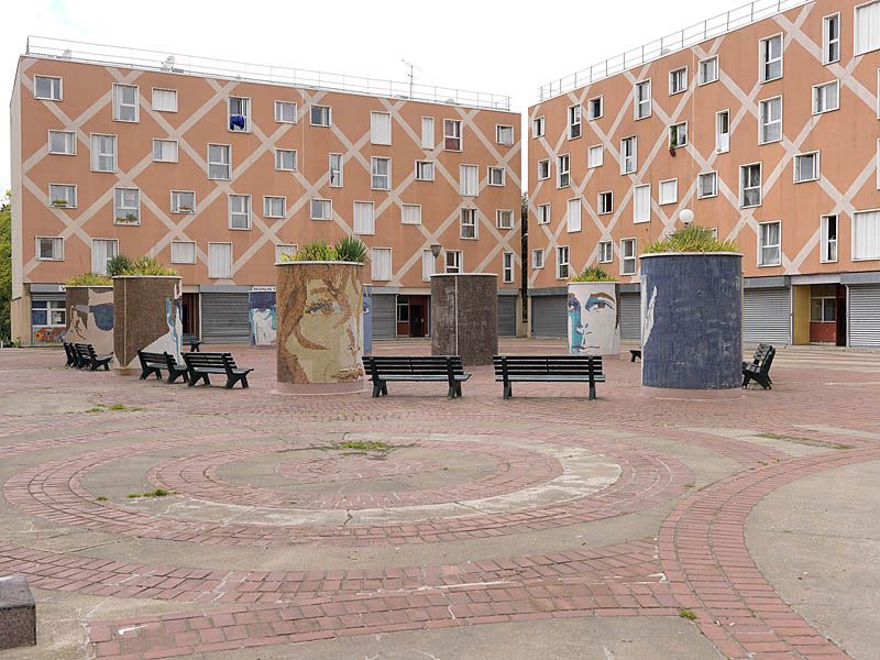 Cité de la Grande Borne à Grigny, Viry-Châtillon. ; Place aux herbes avec bacs à fleurs décorés de mosaïques représentant des visages.