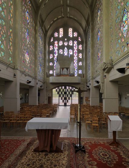 Vue d'ensemble de la nef depuis le choeur. On aperçoit la grande grille d'entrée en fer forgé.
