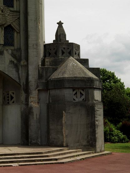 Vue extérieure de la chapelle des fonts baptismaux surmontés de la croix voilée.
