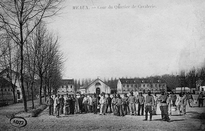 Carte postale, vers 1900 : cour du quartier de cavalerie. On voit au fond la façade du manège. (AD Seine-et-Marne. 2 Fi 4407)