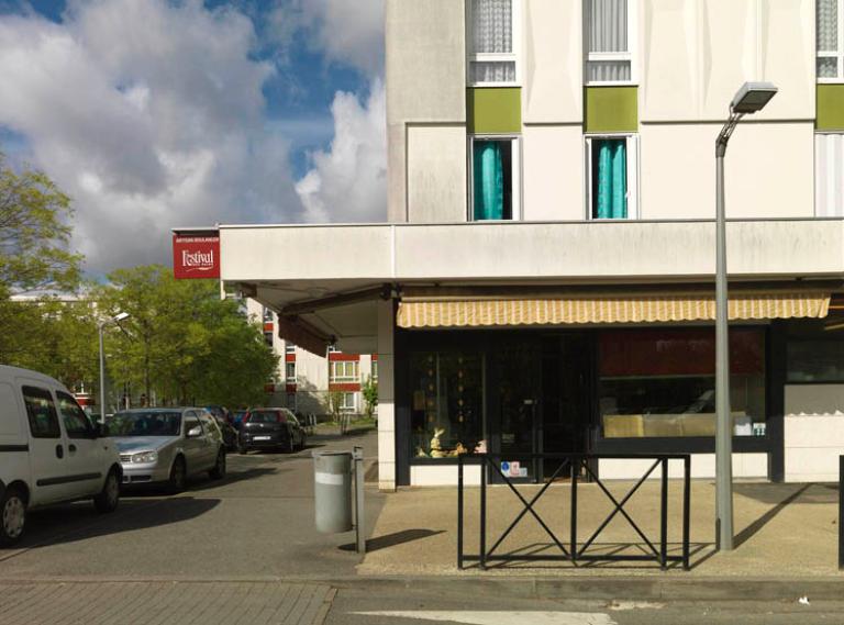 Commerce de proximité en rez-de-chaussée d'un immeuble du secteur du Château, ouvrant sur la place du Marché. 