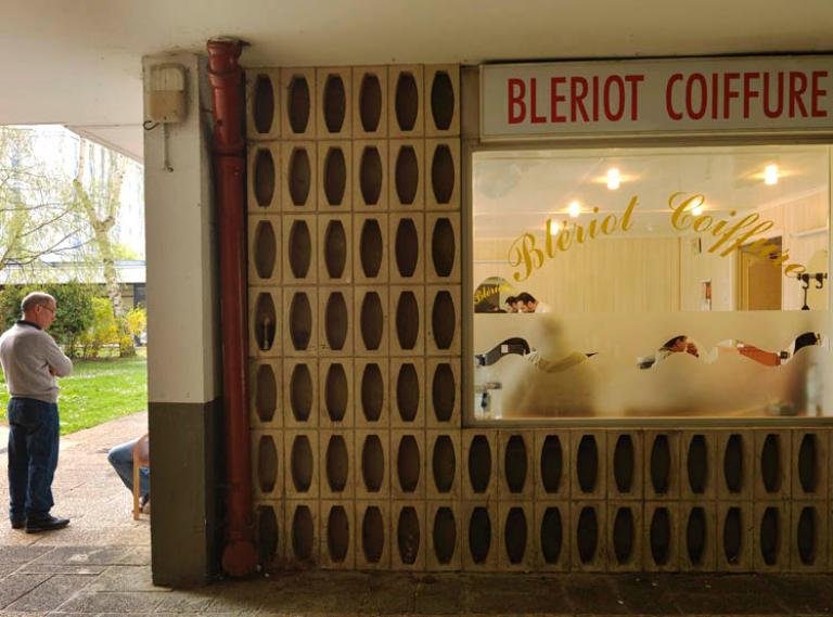 Devanture d'un coiffeur, ouvrant sur le patio intérieur du centre commercial Louis Blériot. 