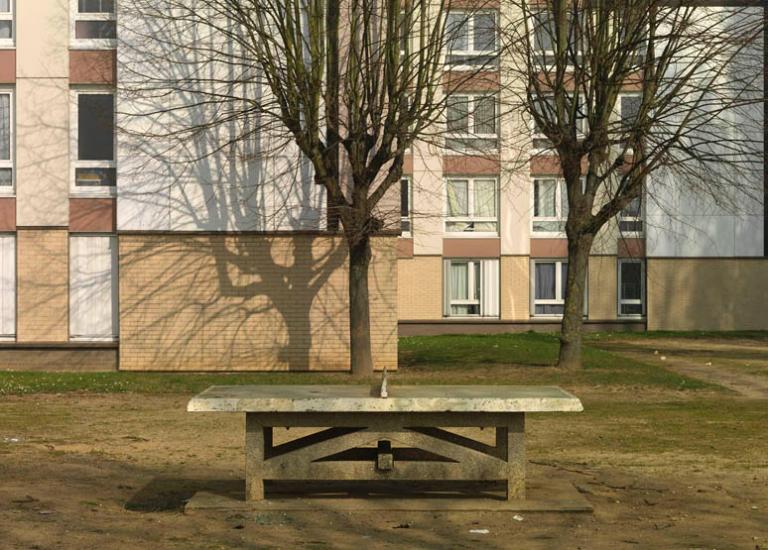 Aire de jeux en bas d'un immeuble. 