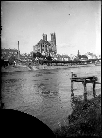 Vue de la collégiale et du quai des Cordeliers depuis l'île. On aperçoit la cheminée de l'ancienne platrière. (Région Ile-de-France. Fonds CREDOP). Plaque de verre.