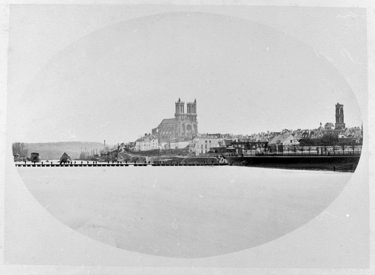 Vue sur Mantes et le pont de bateau provisoire construit après le dynamitage du pont neuf en 1870. (Région Ile-de-France. Fonds CREDOP). Photographie.