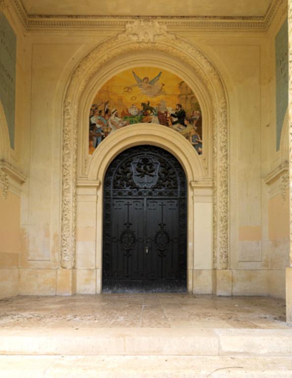 Vue du porche d'entrée et de son tympan décoré. 