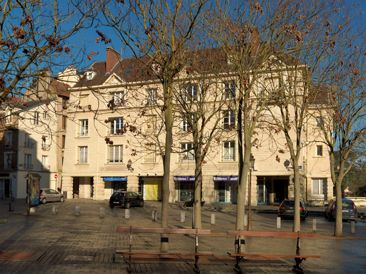 Vue de l'aile à gauche de la place. Les magasins du rez-de-chaussée sont protégés par une galerie dont les piliers sont à bossage continu.