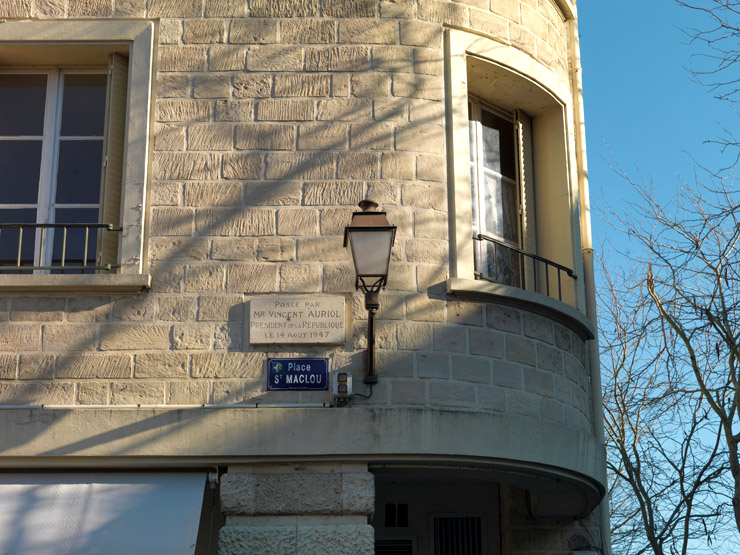 Détail de l'angle du bâtiment à droite de la place. La plaque garde le souvenir du passage de Vincent Auriol, président de la République en 1947.