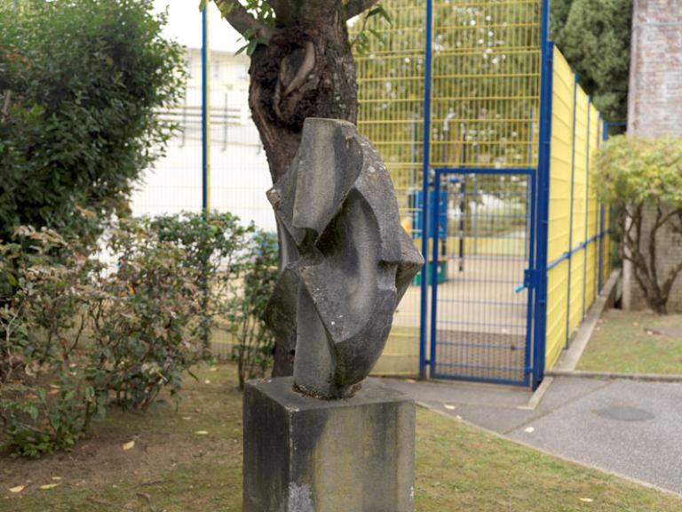 Vue latérale de la sculpture en béton : le Soleil. 