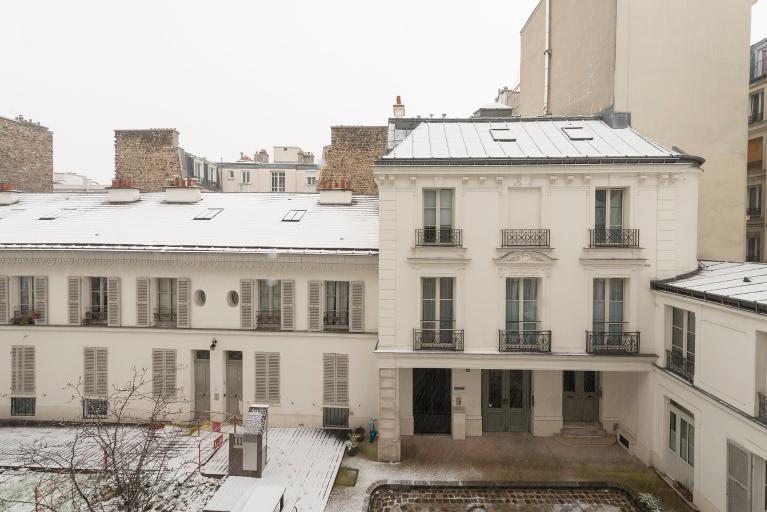 Vue de la façade du bâtiment sur cour abritant le grand escalier doubl, prise depuis le premier étage du bâtiment côté rue Hégésippe Moreau