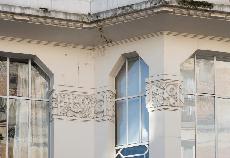 Détail de l'entablement, de la frise décorative et des verrières de la façade donnant sur rue
