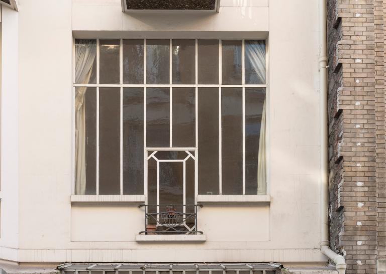 Détail d'une des verrières du premier étage de la façade sur rue