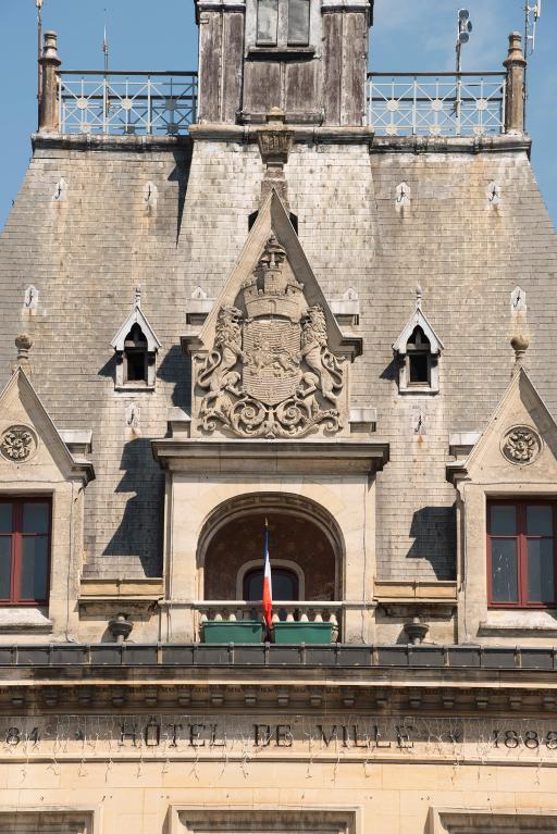 Détail de la lucarne centrale, avec sa loggia et son fronton sculpté aux armes de la ville.