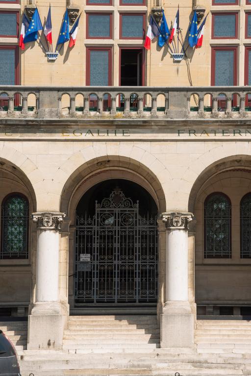 Détail de la façade : l'entrée avec la grille d'honneur et le balcon devant la salle des mariages.