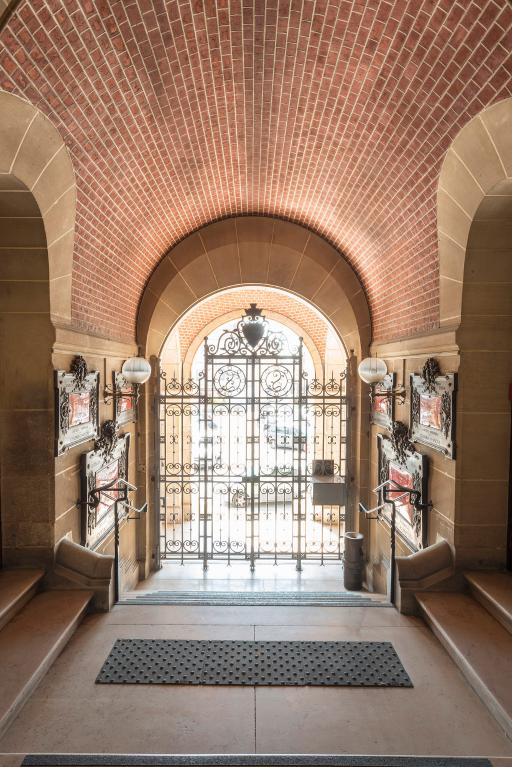 Le vestibule d'entrée, avec sa voûte en brique, les plaques du Souvenir français sur les murs et grille d'honneur au chiffre de La Ferté.
