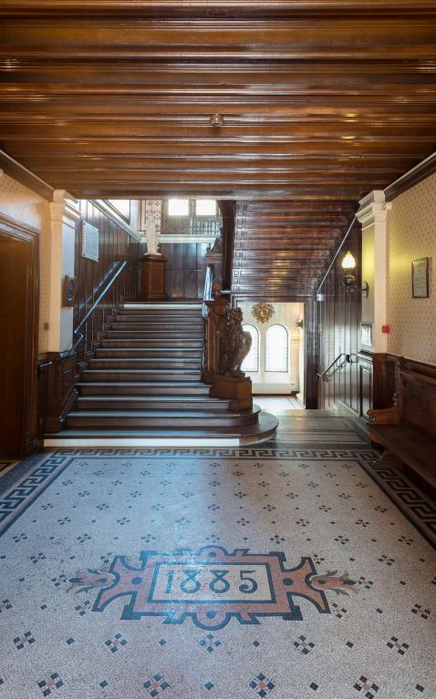 Hall d'entrée de l'hôtel de ville, avec l'escalier d'honneur et la date "1885" inscrite en mosaïque sur le sol.