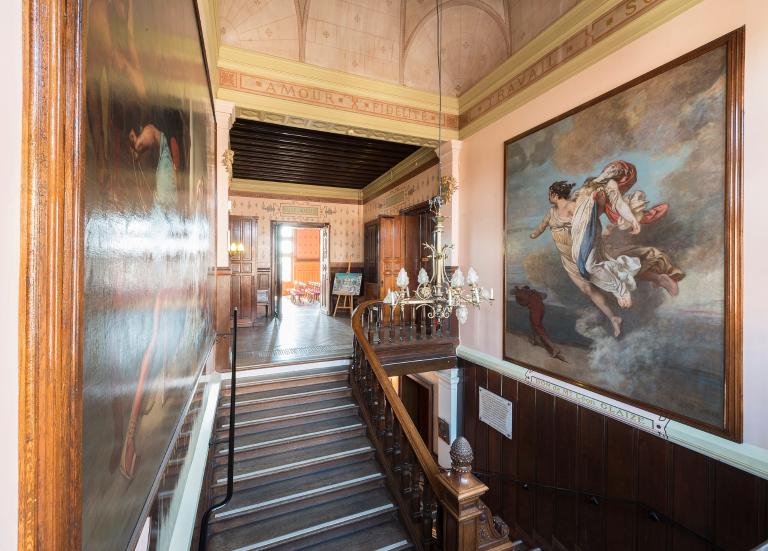 La cage de l'escalier d'honneur : vue d'ensemble, depuis le sud-est. Contre le mur nord, grande toile de Léon Glaize : "Le Triomphe de la République", ou "La République soutenant la France et chassant le régime impérial". Ce motif a été repris par le peintre à la mairie du XXe arrondissement de Paris.