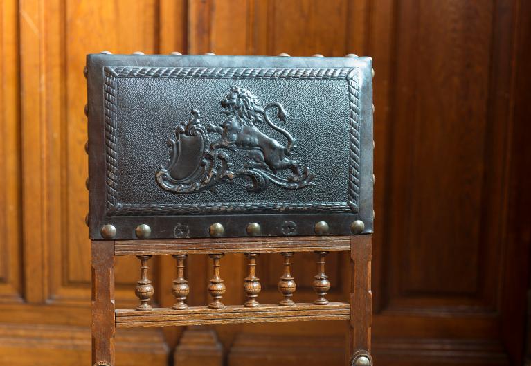 Le dossier d'un fauteuil de la salle du conseil, timbré des armes de la ville.