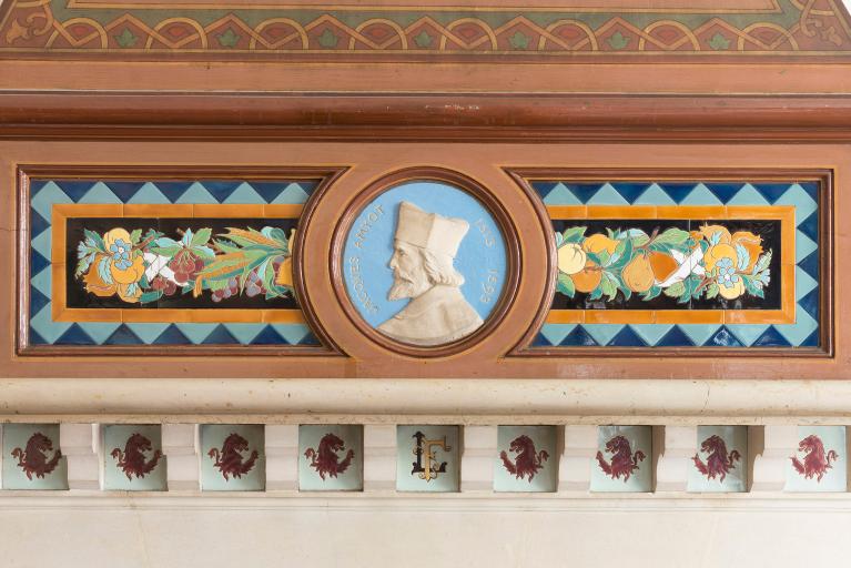 Détail du décor en céramique de la cheminée, centré autour du médaillon de Jacques Amyot (1513-1593), évêque d'Auxerre, traducteur de Plutarque. Ce médaillon est l'oeuvre d'Ernest Leblond, un ami de l'architecte Paul Héneux.