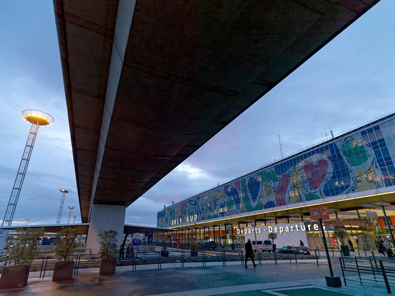 2018, Orly-Sud, la façade de l'aérogare est décorée d' "Orlove" une œuvre de Jean-Charles de Castelbajac, la vue prise depuis le nord ouest sous le viaduc d'Orlyval.