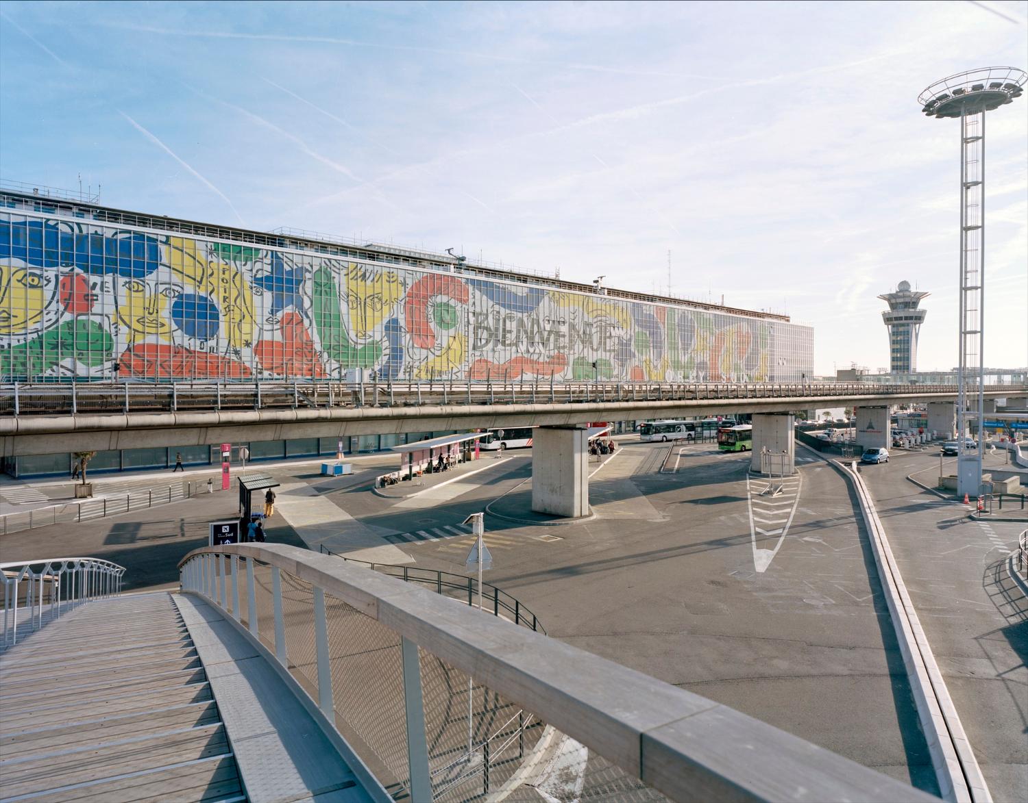 2018, Orly-Sud vu depuis la passerelle "cœur d'Orly" la façade de l'aérogare est décorée d' "Orlove" une œuvre de Jean-Charles de Castelbajac, vue prise depuis le nord est. 