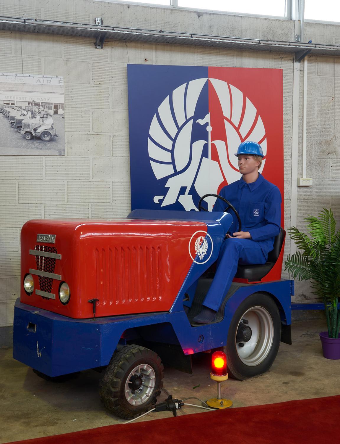 Tracteur de piste "TRACMA, type TE 75, (année de sortie: 1955, moteur Peugeot type 403 Berline, 3 vitesses + marche arrière, poids total: 1100kg, effort de traction: 750 daN, charge tractée: 10/15 tonnes). Ce TRACMA a été restauré en 1991 par le Groupe ADP avec l'aide des sociétés AEROSTOCK et TRACMA. mission Gestion du patrimoine historique du Groupe ADP, Hall 2, bâtiment 615.