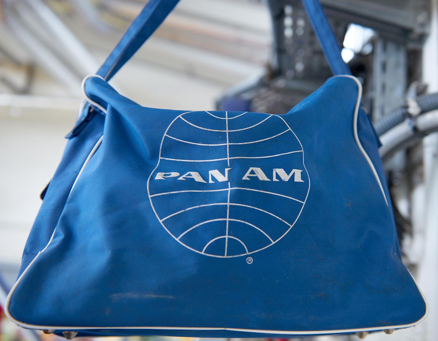 Sac de voyage au couleur de la Pan Am. Le logotype en forme de globe stylisé - globe logo - de la Pan Am est dessiné par d’Edward Larrabee Barnes et Charles Forberg à la fin des années 1950. Mission Gestion du patrimoine historique du Groupe ADP, Hall 1, bâtiment 615.