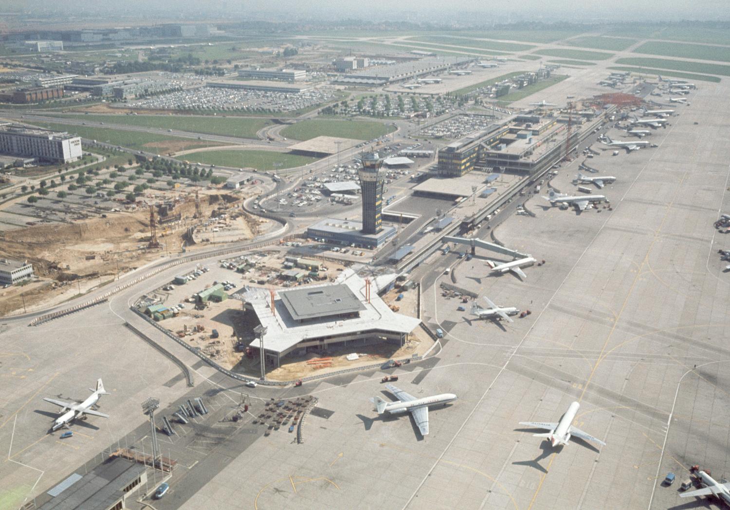 1968, le premier pavillon d'honneur dit l'Isba devant le satellite Ouest en construction. ; 1968 1971, la construction d'Orly-Ouest et des satellites d'Orly-Sud, le satellite ouest, vue prise en 1968 depuis l'ouest.