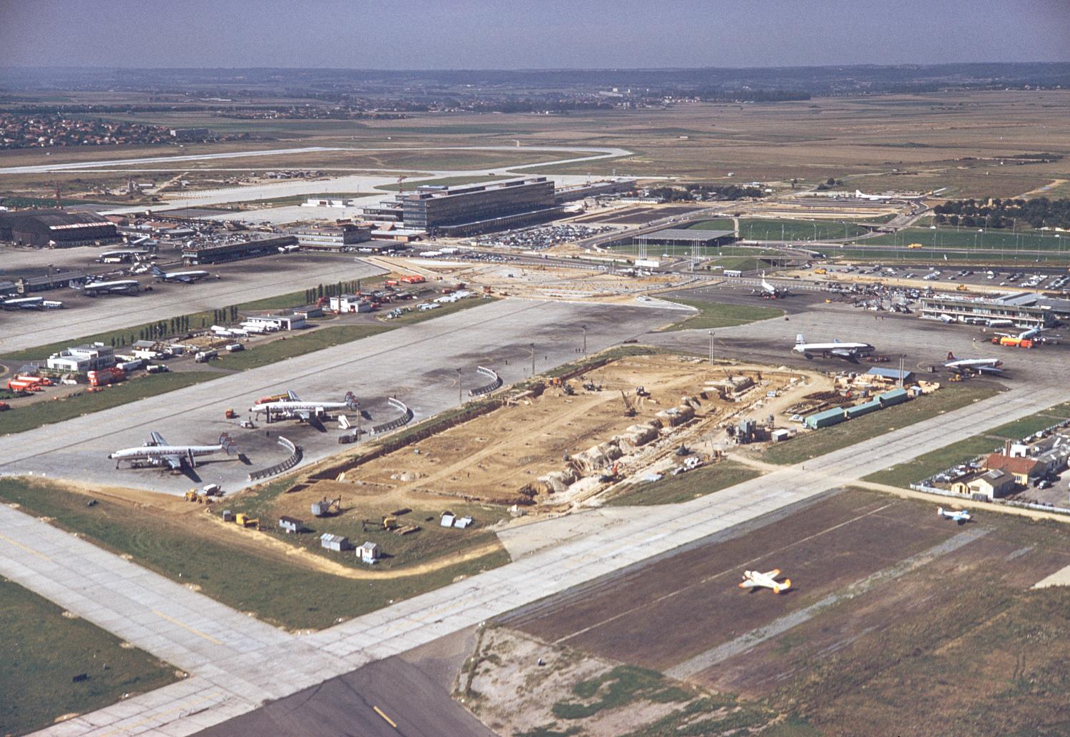 1960, le premier pavillon d'honneur dit l'Isba à son premier emplacement côté piste vu depuis le nord est. ; 1957 1961, la construction des Installations Terminales en 1960, vue prise depuis le nord est