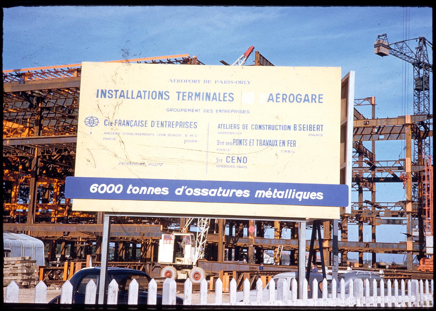 1957 1961, la construction des Installations Terminales, l'ossature métallique en 1959, Panneau présentant les entreprises travaillant sur le chantiers et l'ampleur de la réalisation: 6000 tonnes d'acier vue prise depuis le nord est.