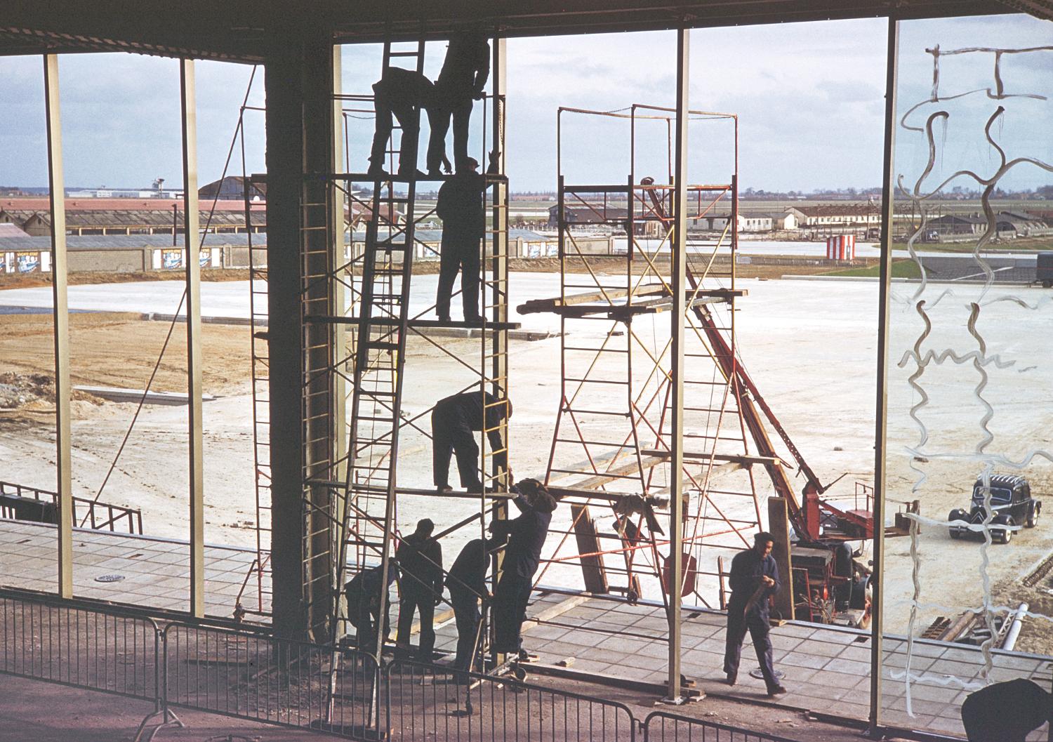 1957 1961, la construction des Installations Terminales: l'installation des dalles en verre du mur-rideau de la façade sud, vue prise depuis la future Galerie Marchande au 1er étage.