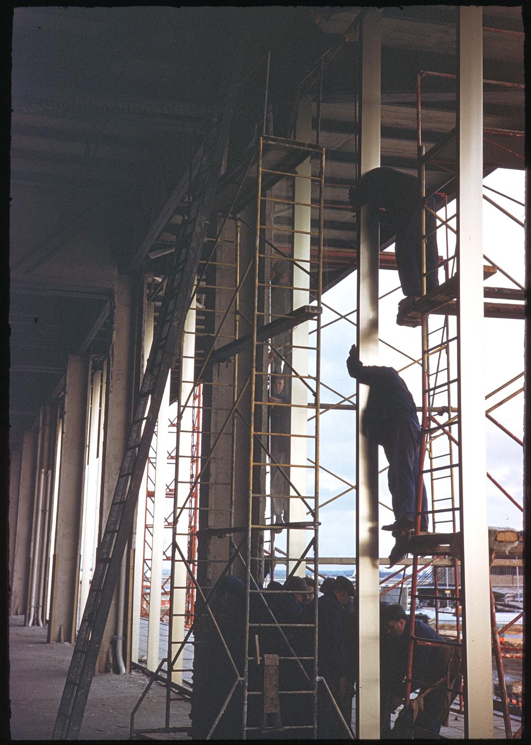 1957 1961, la construction des Installations Terminales: l'installation des dalles en verre du mur-rideau de la façade sud, vue prise depuis la future Galerie Marchande au 1er étage.