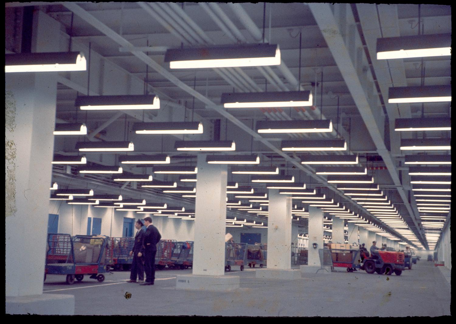 1961, la circulation des bagages, rez-de-chaussée. ; 1961, TRACMA tractant un chariot de fret au rez-de-chaussée des Installations Terminales (aujourd'hui Orly 4).