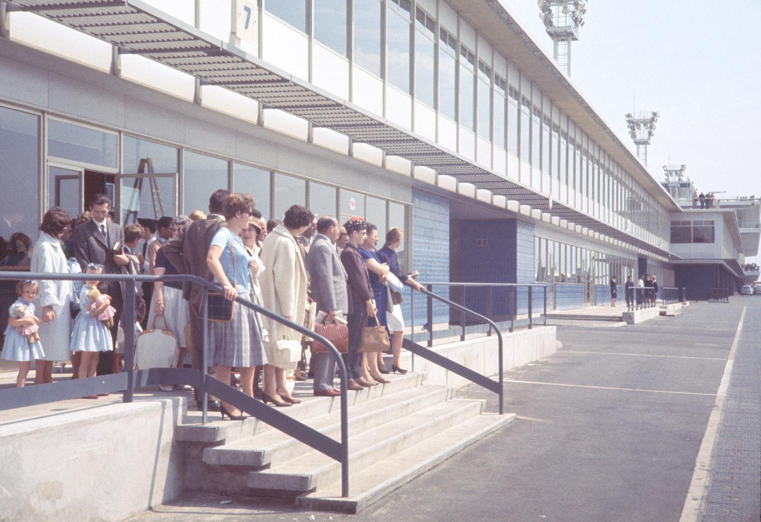 1961, l'embarquement des passagers: l'attente du bus. 