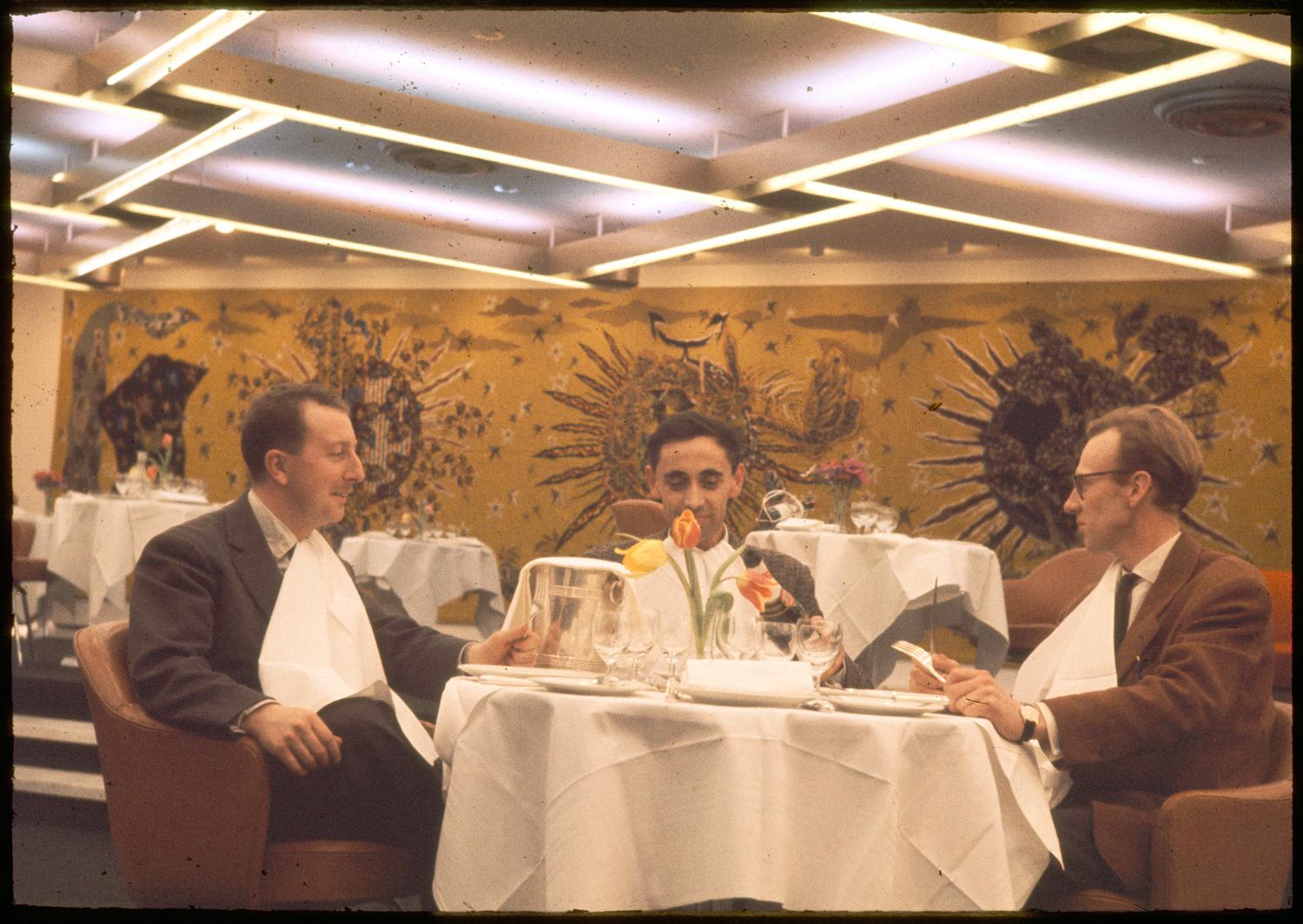 Les Trois Soleils, conception des aménagements André Renou et Jean-Pierre Génisset (la Crémaillère), fauteuils Conférence (Eero Saarinen), au fond de la salle la tapisserie de Jean Lurçat qui donne son nom au restaurant, 3ème étage.  ; Les Trois Soleils, conception des aménagements André Renou et Jean-Pierre Génisset (la Crémaillère), au fond de la salle la tapisserie de Jean Lurçat qui donne son nom au restaurant, 3ème étage.